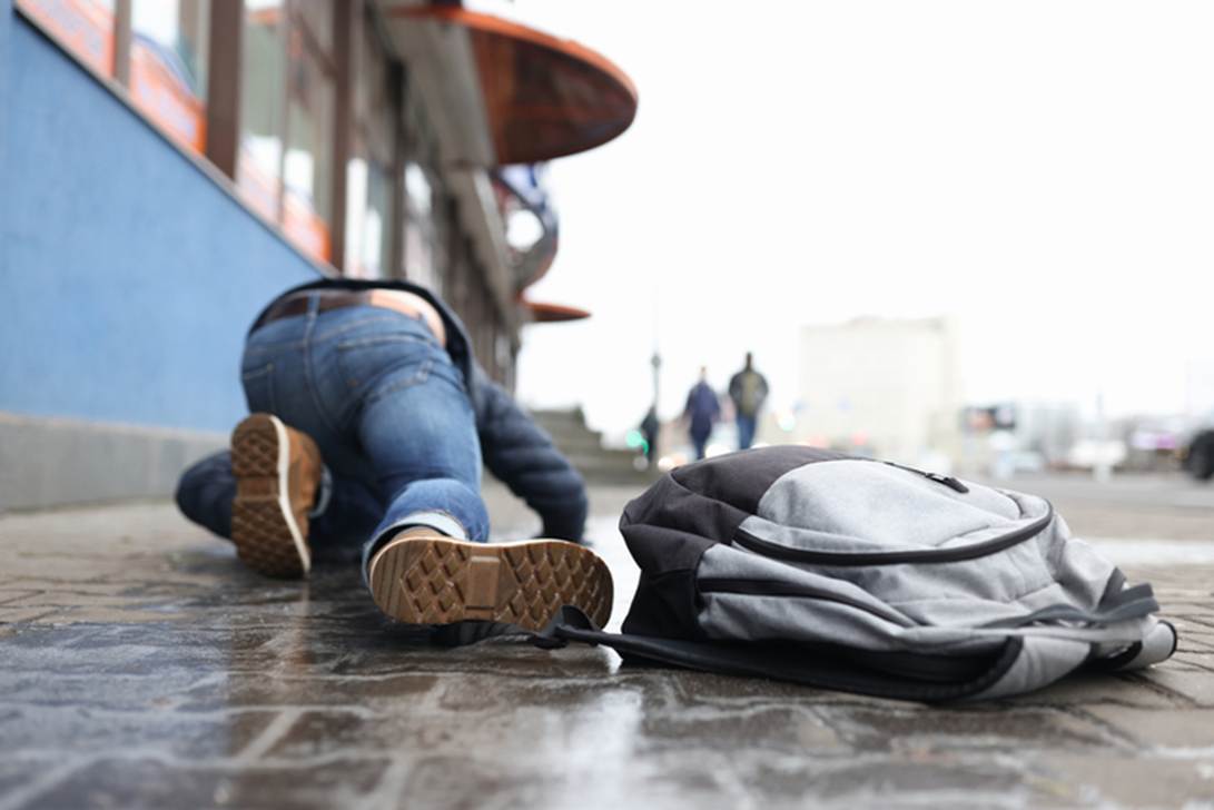 A person lying on the ground next to a backpack

AI-generated content may be incorrect.
